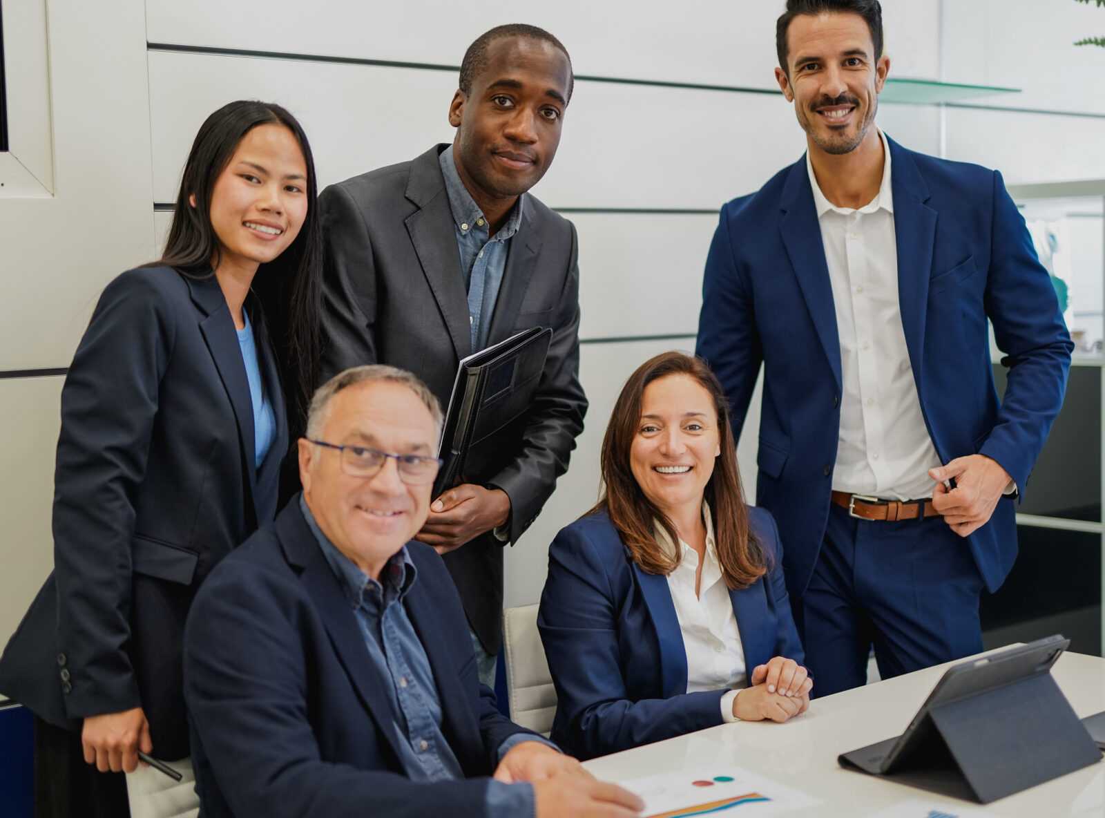 Multiracial business people smiling on camera inside modern offi