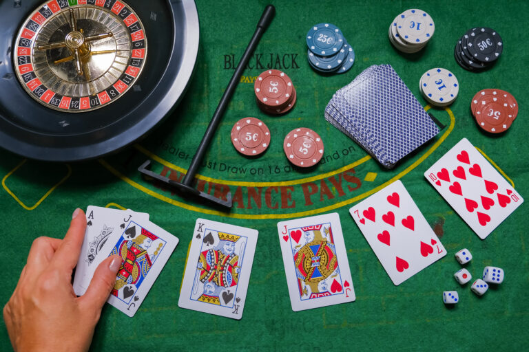 Gambling board game.Cards, chips, roulette.Gaming flat lay. Close-up of a card for playing poker on a gaming table in a casino against a background of chips. Background for the gaming business.