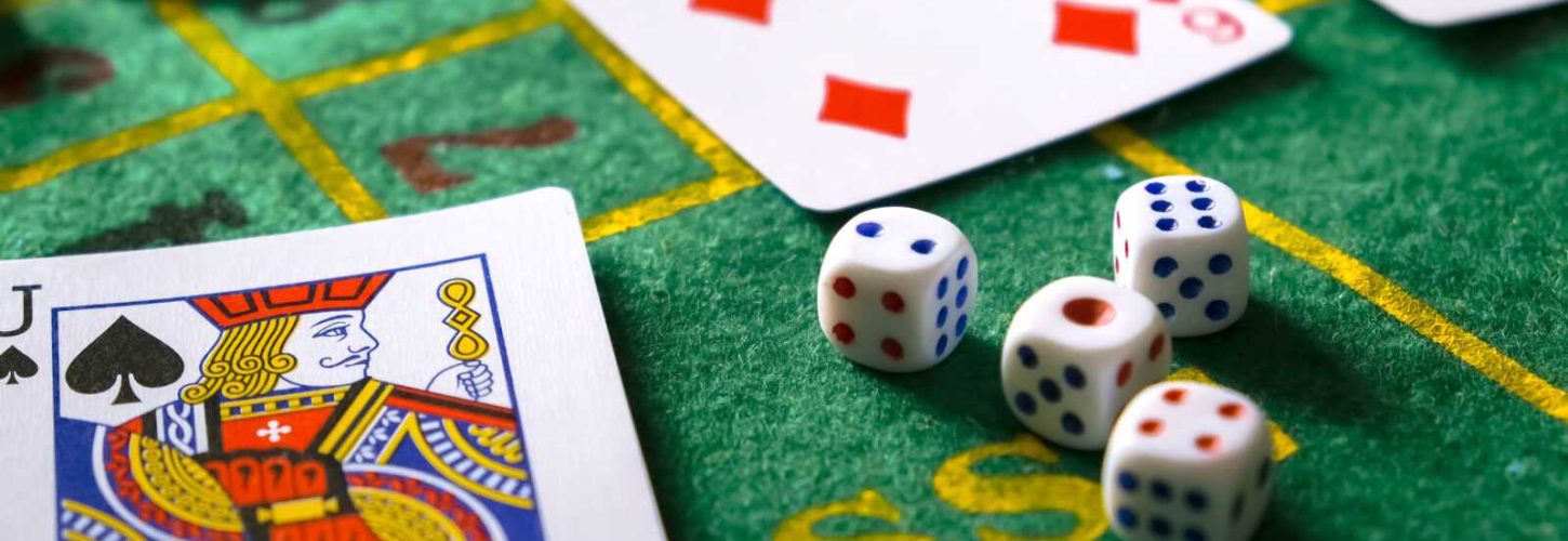 Gambling board game.Cards, chips, roulette.Gaming flat lay. Close-up of a card for playing poker on a gaming table in a casino against a background of chips. Background for the gaming business. Gambling board game.Cards, chips, roulette.Gaming flat lay. Close-up of a card for playing poker on a gaming table in a casino against a background of chips. Background for the gaming business.